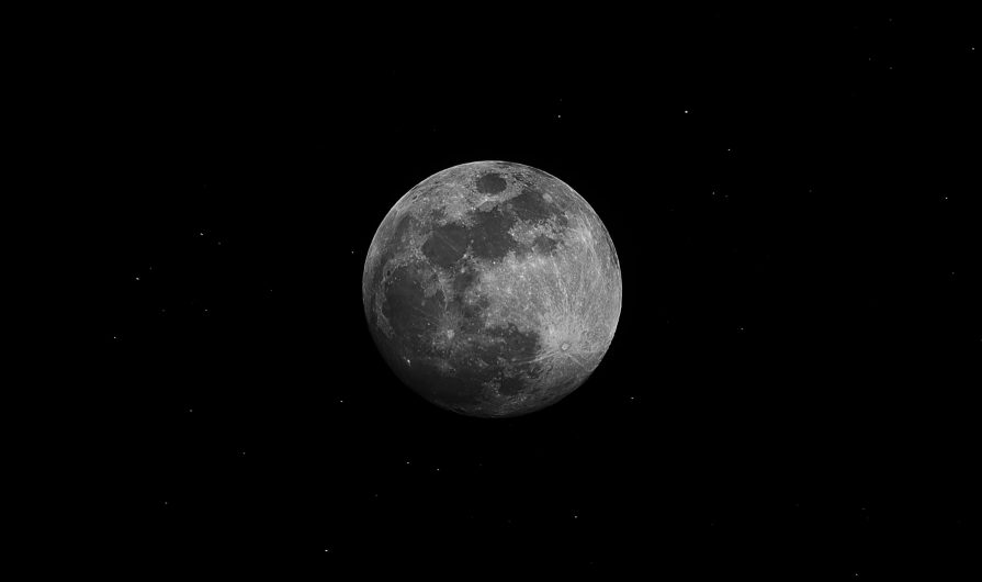 Black and white photograph of the moon in a black sky.